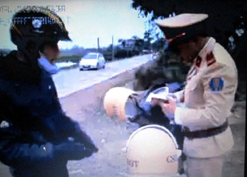 Hình ảnh cảnh sát giao thông mở sách luật ra tra cứu khung xử phạt trong clip